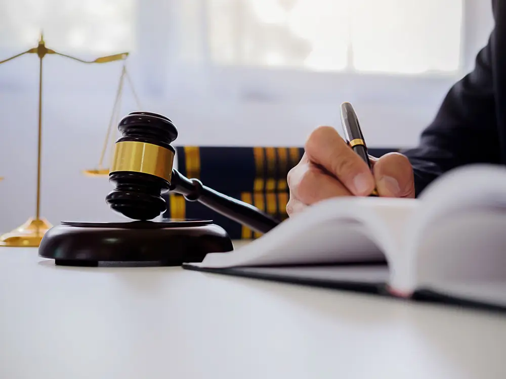 Juiz togado no tribunal, com a mão no queixo, analisando um caso ou proferindo uma decisão.